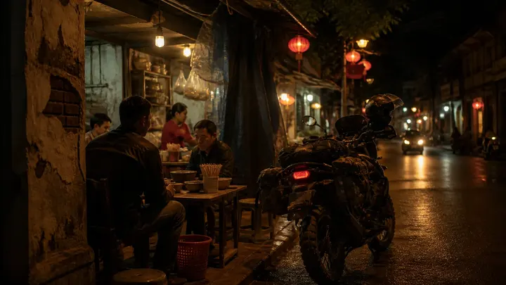 Adventure motorcycle parked outside a warm local night food stall in Southeast Asia.